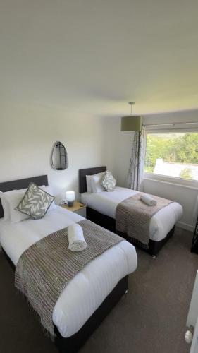 a hotel room with two beds and a window at Donrae in Portree