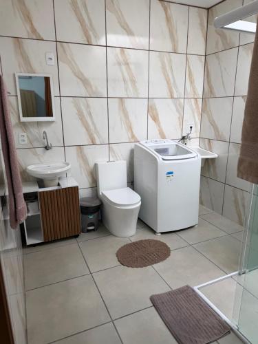 a bathroom with a toilet and a sink at Casa aconchegante in Timbó