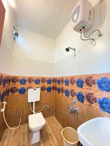 a bathroom with a toilet and a flower mural on the wall at La Couronne Seaview Resort in Pondicherry