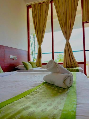 a hotel room with two beds and a window at La Couronne Seaview Resort in Pondicherry