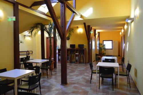 a restaurant with tables and chairs in a room at Bordany Hostel in Bordány