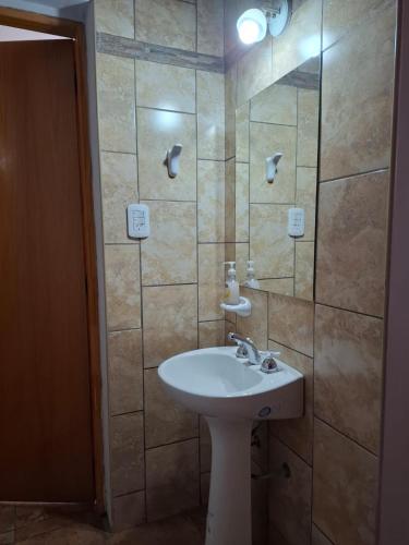 a bathroom with a sink and a shower with a mirror at Brisas Andinas in Malargüe
