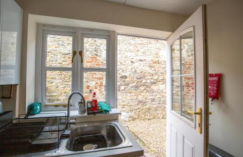 a kitchen with a sink and a window at 2 Crown Barton in Glastonbury