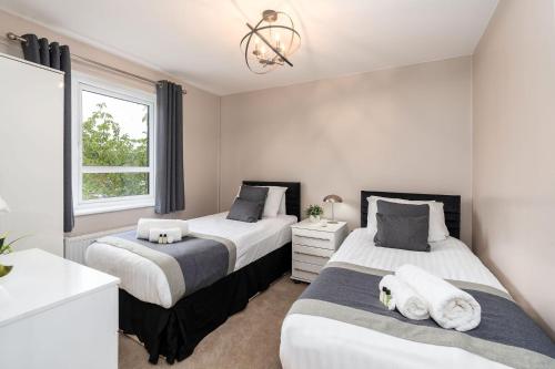 a bedroom with two beds and a window at Meadow Park Villas in Manchester