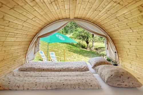 a couple of beds in a tent with an umbrella at Übernachtungsfaß in Alpirsbach