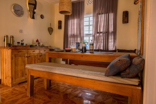 a kitchen with a bench and a table in a room at Utamaduni House B&B in Arusha