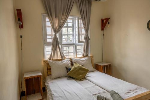 a bed in a room with a large window at Utamaduni House B&B in Arusha
