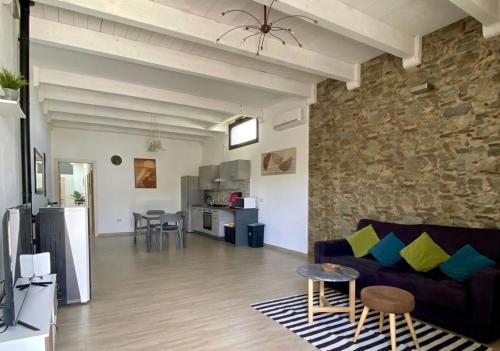 a living room with a couch and a stone wall at Copernico casa vacanze, nel centro di Lecce in Lecce