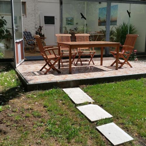 a wooden picnic table and chairs on a patio at Haus Nähe Flughafen und Messe in Düsseldorf
