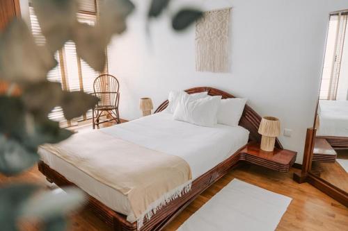 a bedroom with a bed with white sheets and pillows at Casa do Suave Mar in Esposende