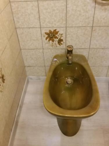 a bronze toilet in a bathroom with a tiled wall at Haus Nähe Flughafen und Messe in Düsseldorf