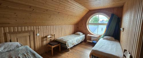 a room with two beds in a wooden room at Ranna Resort Hostel in Pärnu