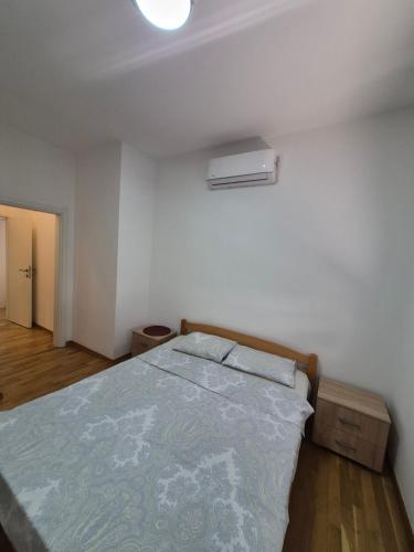a white bedroom with a bed with at M&M Apartman 2 in Rafailovici