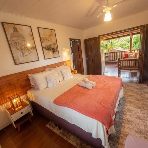a bedroom with a large bed with an orange blanket at Residência Thomas in Itacaré
