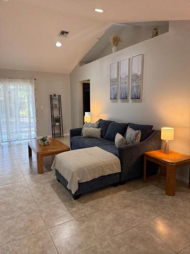 a living room with a blue couch and a table at Seras Home At Vero Beach in Vero Beach