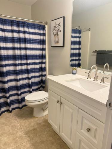 a bathroom with a sink and a toilet and a mirror at Seras Home At Vero Beach in Vero Beach