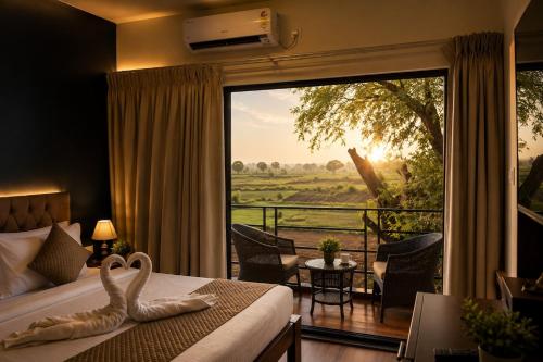 a hotel room with a bed and a large window at Prakruthi Retreat Belagavi in Belgaum