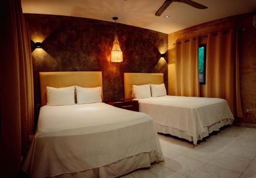 a bedroom with two beds with white sheets at Petra By Ariché in Valladolid