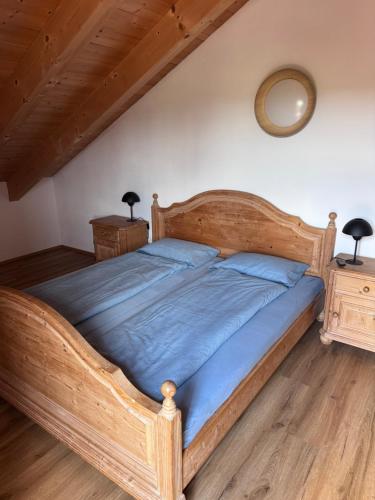 a wooden bed in a bedroom with a wooden floor at Ferienwohnung Grecht in Uffing