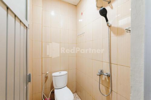 a bathroom with a shower with a toilet in it at Wisma Merdeka Syariah RedPartner in Palembang