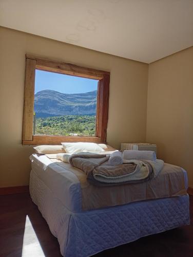 a bedroom with a large bed with a window at Hospedaria Portal das Montanhas in Ibicoara