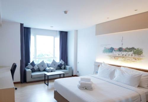 a hotel room with a bed and a couch at Parinda Hotel - near Benjakitti Park & Queen Sirikit National Convention Center in Bangkok