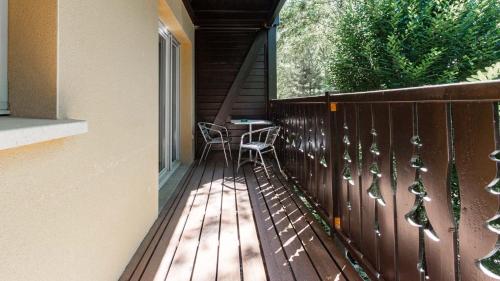 a wooden deck with a table and chairs on it at Les Chalets d Ax N120 2P6 in Ax-les-Thermes