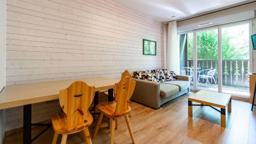 a living room with a table and chairs and a couch at Les Chalets d Ax N120 2P6 in Ax-les-Thermes