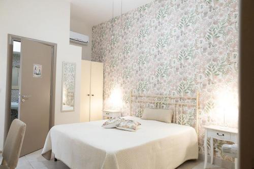 a bedroom with a white bed and a pink wall at Dimora dei Grifi in Ascoli Satriano