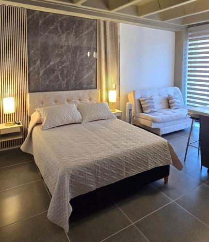 a bedroom with a large bed and a couch at apartamento tipo loft en sabaneta in Sabaneta