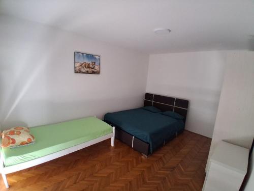 ein Schlafzimmer mit zwei Betten und einem Bild an der Wand in der Unterkunft Radoš in Igalo