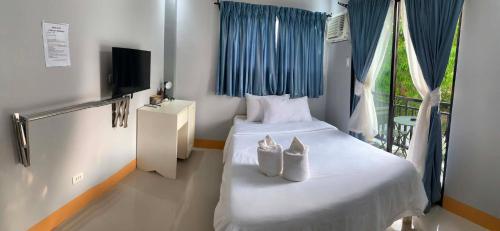 a bedroom with a bed with two shoes on it at ANDABAY Tourist Inn in Anda
