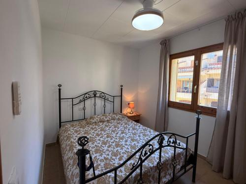 a bedroom with a bed and a lamp and a window at La dorada 8 in Torroella de Montgrí