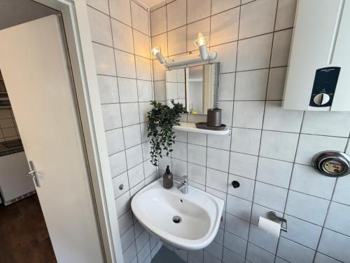 a white bathroom with a sink and a mirror at Gemütliches Studio direkt am Marktplatz Boppard in Boppard