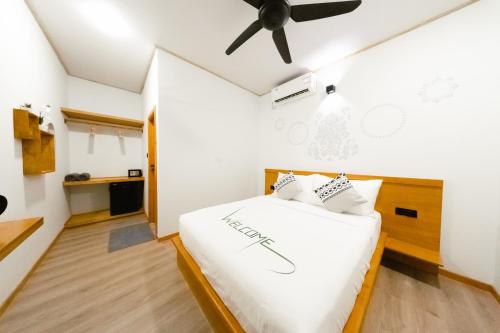 a bedroom with a bed with a ceiling fan at Oasis Retreat Dhiffushi in Dhiffushi