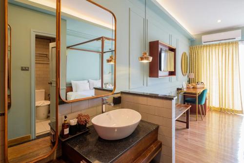a bathroom with a sink and a large mirror at The Craft Nimman in Chiang Mai