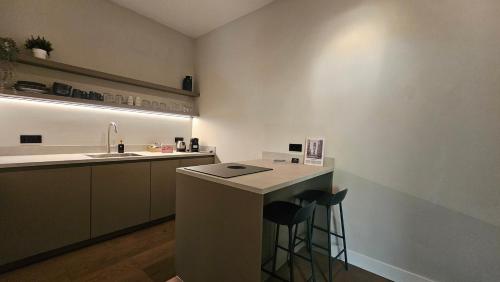 a kitchen with a sink and a counter with stools at Guest Room Utrecht in Utrecht