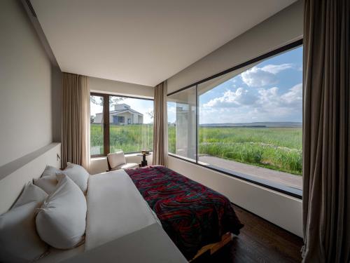 a bedroom with a bed and a large window at Things grow in their native land in Ulanqab