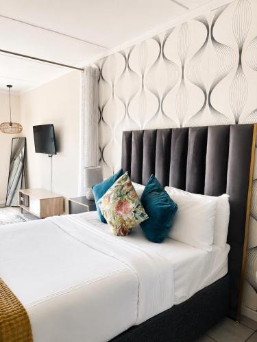 a bedroom with a large white bed with blue pillows at MANDITAZ STUDIO in Fourways