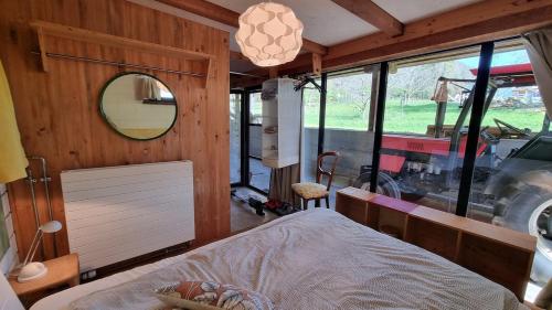 ein Schlafzimmer mit einem Bett in einem Zimmer mit einem Spiegel in der Unterkunft Tiny farm studio in Maggia