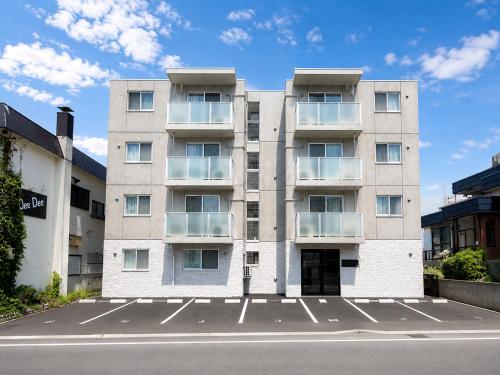 a building with a parking lot in front of it at Excel 琴似 -FIX HOME- in Sapporo