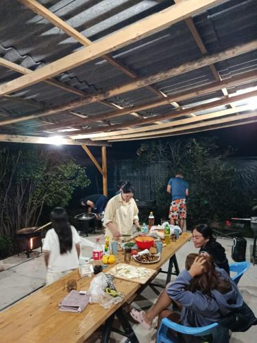 a group of people sitting around a table preparing food at 40 Rays Yurts in Bosteri
