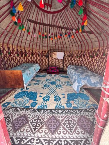 a room with a bed and a rug in a yurt at Almani yurt camp in Tong