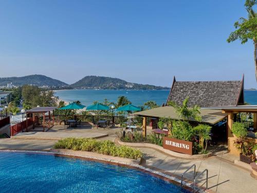 a resort with a swimming pool with a view of the water at Novotel Phuket Resort in Patong Beach