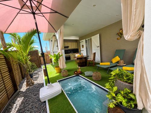 a backyard with a swimming pool and an umbrella at Le SeaZen Lodge in Sainte-Anne