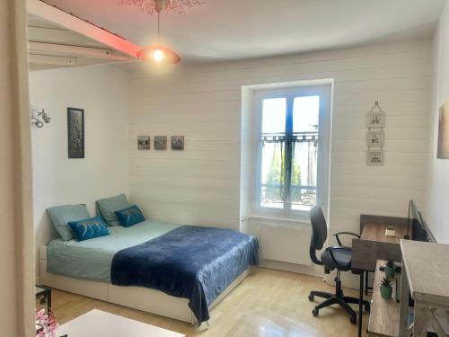 a bedroom with a bed and a desk and a window at Studio -Center - Lorient in Lorient