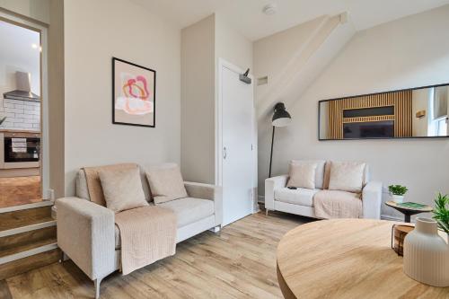 a living room with two chairs and a table at Cosy Two Bed House (16BLR) in Leeds