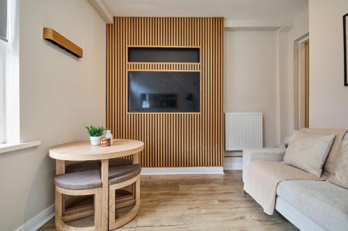 a living room with a couch and a table and a television at Cosy Two Bed House (16BLR) in Leeds