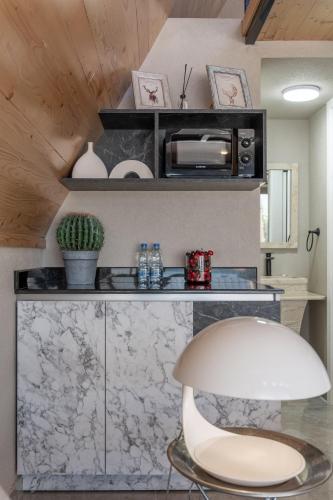 a white chair in a room with a counter at Maison Jwar - Luxury A-Shape Cabins - A Unique Summer Getaway in Ḩārat at Taḩtā