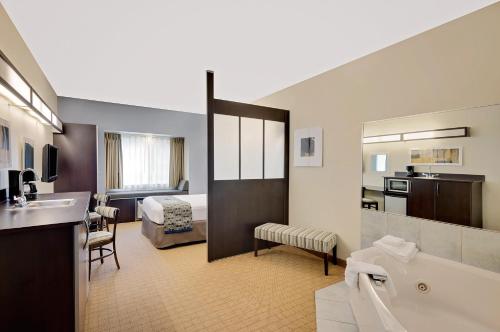 a hotel room with a bathroom and a bedroom at Microtel Inn and Suites by Wyndham - Geneva in Geneva